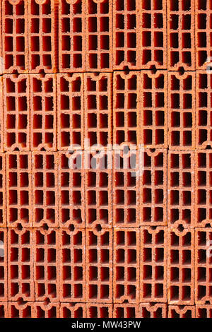 Stacked orange bricks. Construction industry. Industrial objects. Architecture. Vertical Stock Photo