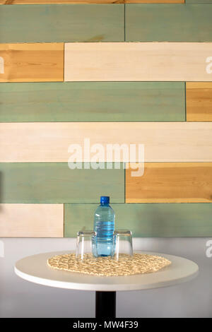 Bottle of water with glasses on table Stock Photo