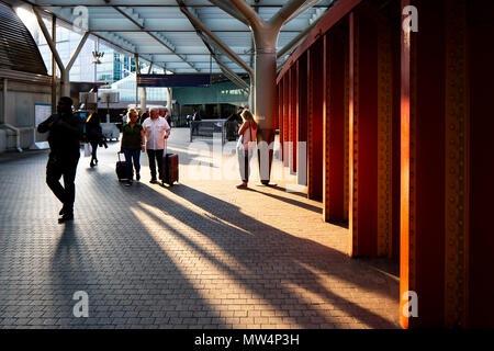 London, Paddington Station Early evening image of people passing through train station  Mix of Modern and industrial buildings with people in shadow Stock Photo