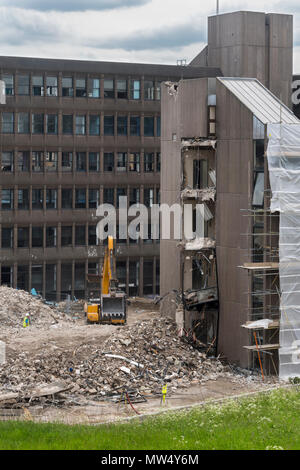 High view of demolition site - heavy machinery (excavator) in piles of rubble working & demolishing office building - Hudson House  York, England, UK. Stock Photo