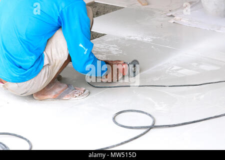 Industrial tiler builder worker working with floor tile cutting equipment Stock Photo