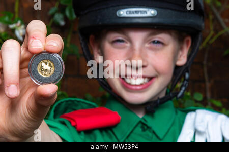 Abi Evans holds a Gold Quarter Sovereign which features a portrait of Queen Elizabeth II on horseback during the launch of the coin with the Horse Rangers Association, at the Royal Mews in Hampton Court, Surrey. Stock Photo