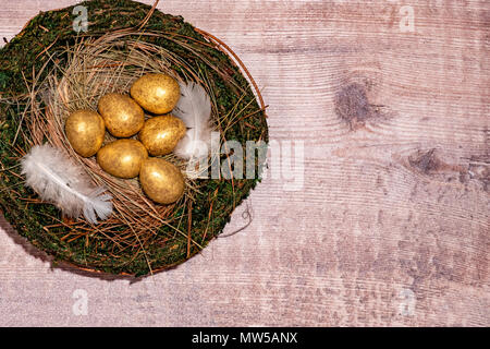 Gold eggs in a bird’s nest Stock Photo