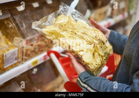 Packing of potato chips in the buyers hand in the grocery store Stock Photo