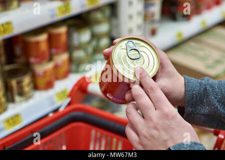 Tin can in the hands of the buyer Stock Photo