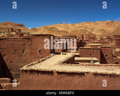 Traditional Moroccan clay houses with flat roofs, high clay walls and small windows in the Atlas mountain gorge. Stock Photo