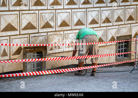 Worker cleaning dirty wall with high pressure water jet. Building exterior cleaning. Stock Photo