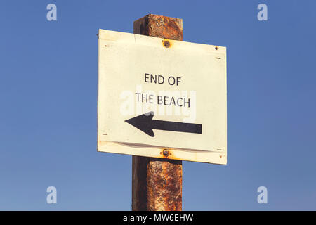 End of the beach metal sign with blue sky background.  Vintage style. Stock Photo