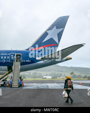 Passengers boarding LATAM airline Dreamliner Boeing 787, during rain weather at Mataveri International Airport runway, Easter Island, Chile Stock Photo