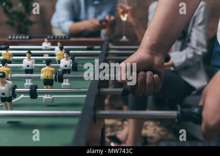 Close-up partial view of young people playing foosball indoors Stock Photo