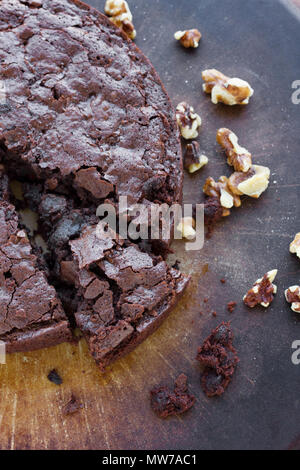 Chocolate fudge brownie dessert cake with walnuts and powdered sugar, sliced into pie slices. Stock Photo