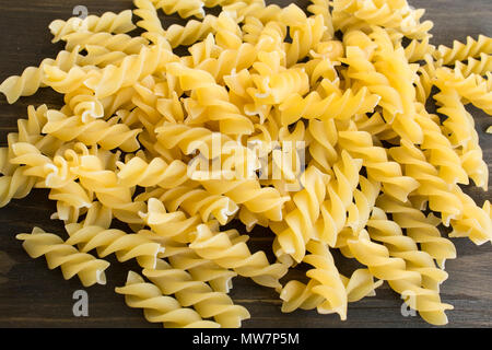 Italian Pasta Fusilli on a Wooden Background. Stock Photo