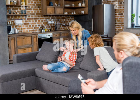 parents with two little kids spending time at home Stock Photo