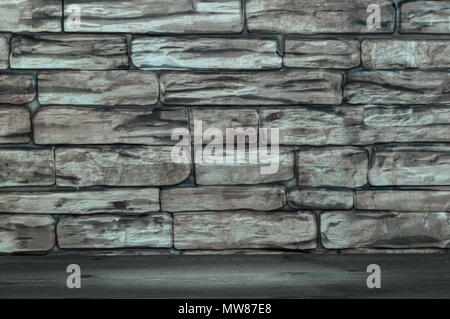 The wall is made of large bricks and wooden boards with a spot of illumination. Stock Photo
