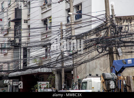 Messy wires attached to the electric pole, the chaos of cables and wires on an electric pole in Bangkok, Thailand, concept of electricity Stock Photo