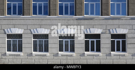 Texture of a glazed modern windows of a grey concrete building. Close-up photo of a concrete wall with plastic windows Stock Photo