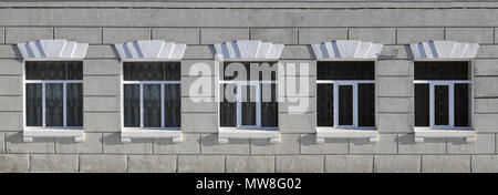 Texture of a glazed modern windows of a grey concrete building. Close-up photo of a concrete wall with plastic windows Stock Photo