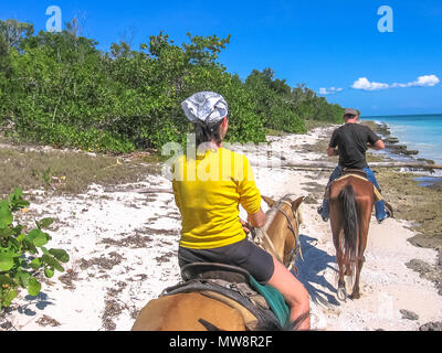 Bayahibe, Dominican Republic - May 26, 2006: tourists on horseback along the coast of the Parque Nacional del Este, Dominican Republic. Horse riding is an activity very practiced in Bayahibe. Stock Photo