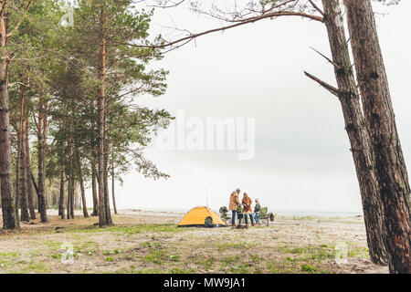 happy family having picnic on seashore on cold autumn day Stock Photo