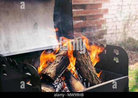Fire over wooden logs in outdoors bbq Stock Photo