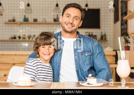 cute smiling son and father sitting in cafe Stock Photo