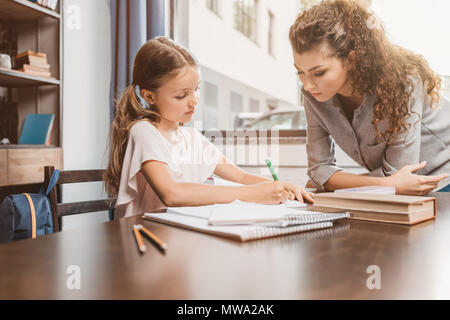 beautiful young mother and daughter doing homework together Stock Photo