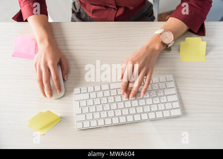cropped shot of manageress typing on keyboard with blank stickers on work desk Stock Photo