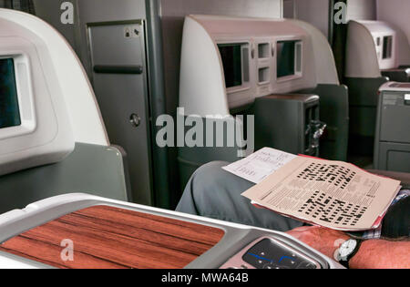 Business Class seats LATAM airlines Dreamliner 787 with man doing Guardian Easter Crossword, flying from Easter Island to Santiago Stock Photo