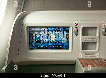Business Class seats LATAM airlines Dreamliner 787 flying from Easter Island to Santiago, with video console showing in flight entertainment movies Stock Photo