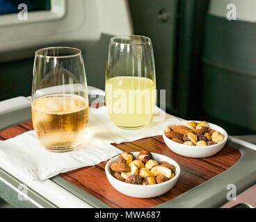 Business Class seats LATAM airlines Dreamliner 787 flying from Easter Island to Santiago; pisco sour and sparkling wine welcome drinks with mixed nuts Stock Photo