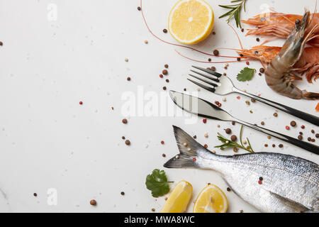 Shrimps and fish with spices and silverware isolated on white Stock Photo