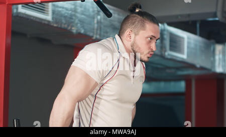 Young strong man doing biceps exercises in the gym Stock Photo