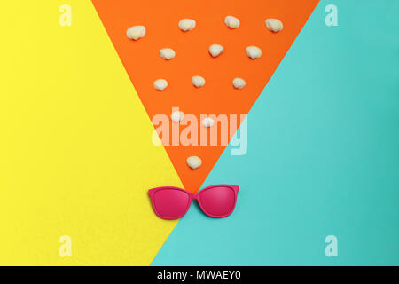 One big starfish on colorful background and many small sea shell on orange background. Top view. Summer time. Sea style. Creative concept. Stock Photo