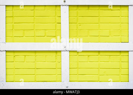 Painted yellow brick wall texture, metal white quadrangular frame, urban background, space for text. Abstract light backdrop, pattern, wallpaper, banner design, place for text