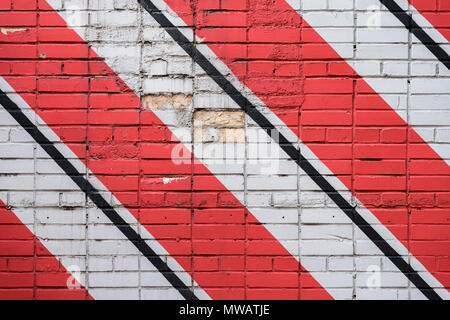 Diagonally painted bricks surface of wall in red, black and white colors, as graffiti. Graphic grunge texture of wall. Abstract geometric modern background Stock Photo