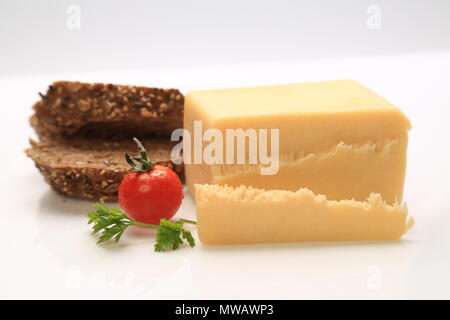 Sliced cheese with a cherry tomato on the side Stock Photo