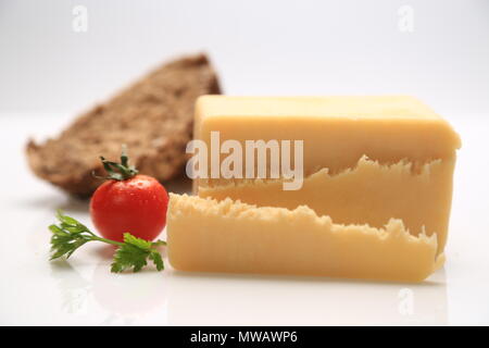 Sliced cheese with a cherry tomato on the side Stock Photo