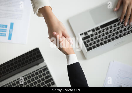 Female hands shaking at meeting making deal, top closeup view Stock Photo