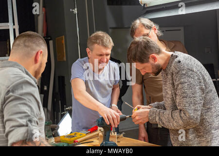 profession, carpentry, woodwork and people concept, carpenters prepares the drill for work Stock Photo