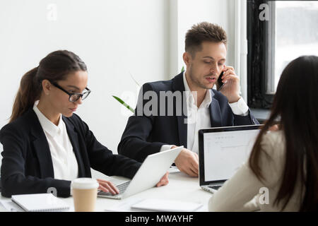 Executive business people using laptops for work, talking on pho Stock Photo