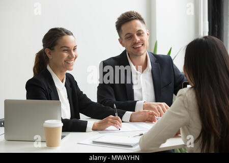 Friendly team members chatting laughing together during office b Stock Photo