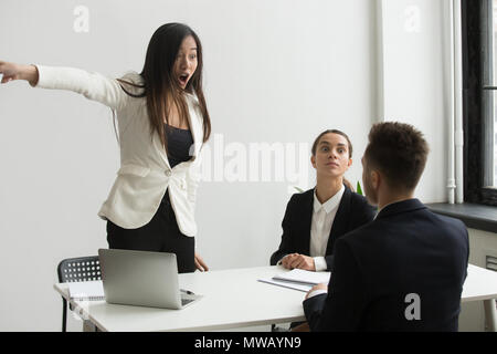 Furious businesswoman angry at businessman telling to leave mult Stock Photo