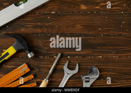 collapsible meter, hammer, adjustable wrench, spanner, chisel and spirit level on wooden surface Stock Photo