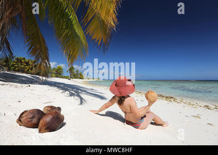 Woman sitting on a tropical beach Stock Photo