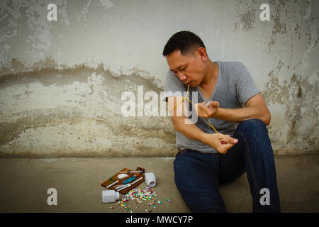 Concept Asia man is sad and pain by drug addiction problem. Stock Photo