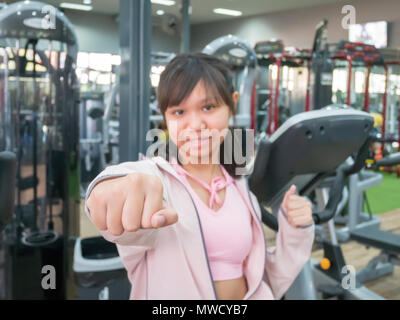 Asian teenage girl acting punch she smile and relax after exercise in the gym. Stock Photo