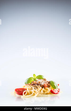 Spaghetti bolognese basil tomatoes and parmesan cheese on white background. Stock Photo