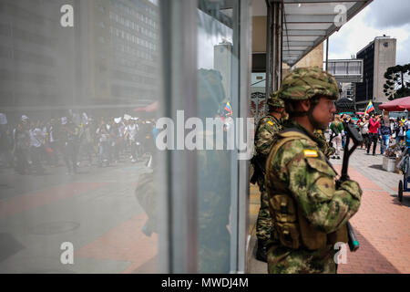 Bogota, Colombia. 31st May, 2018. A soldier accompanies the march from afar. After the presidential elections in Colombia on May 27, some alterations have been found in the formats of vote counting. The total numbers of votes have been altered to give more votes to certain candidates. On May 31, a march was organized to demand that the National Registry of Colombia act in this regard. Credit: SOPA Images Limited/Alamy Live News Stock Photo