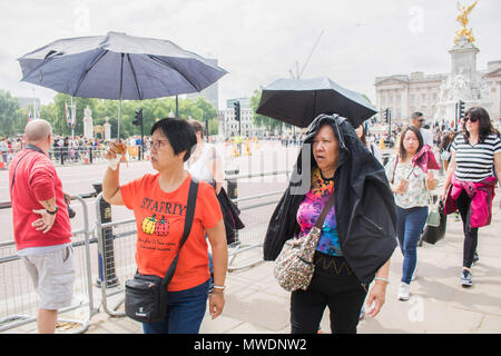 London UK. 1st June 2018. tourists shelter outside Buckingham Palace  under and umbrella on a hot humid day in London Credit: amer ghazzal/Alamy Live News Stock Photo