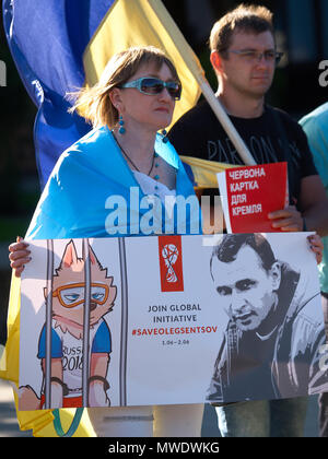 Kryvyi Rih, Ukraine. 1st June 2018.  Woman holds poster with portrait of crimean director Oleg Sentsov and call to join global initiative '#FreeOlegSentsov' and Zabivaka (official mascot of 2018 FIFA World Cup) behind bars during the action 'Free Sentsov' in Kryvyi Rih (Ukraine) on June 1, 2018 Credit: Dmytro Aliokhin/Alamy Live News Stock Photo